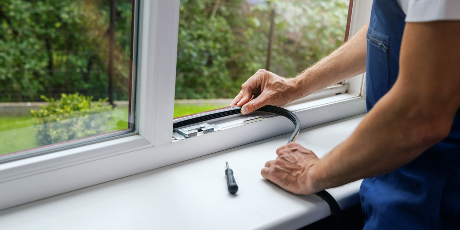 Tech installing Additional protection from drafts in window - How to Get the Most from Your Air Conditioner this Summer