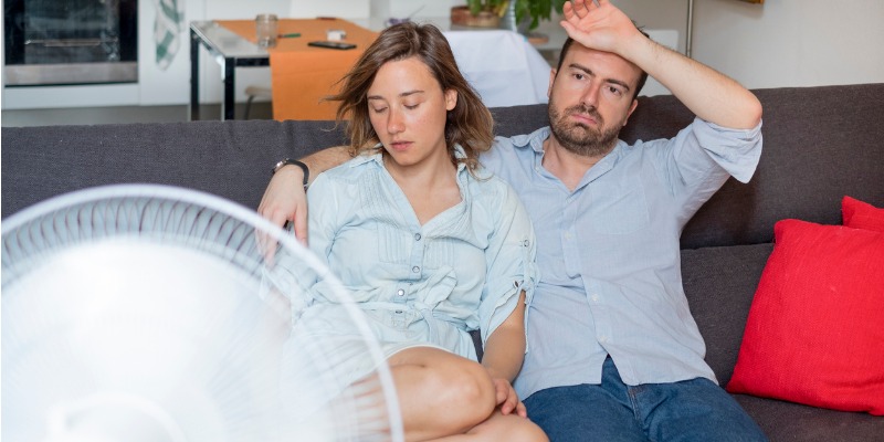couple sitting in front of fan